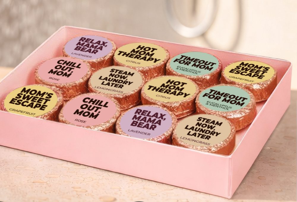 Open Mesmos box showing twelve foil-wrapped shower steamers